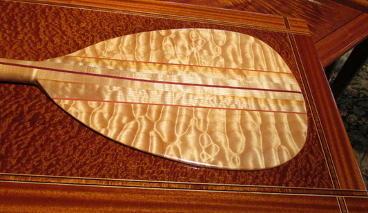 Quilted Maple Canoe Paddle on a Sapele table